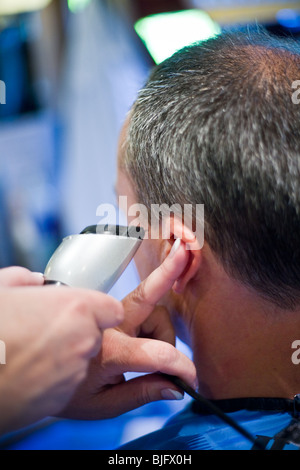 Coiffure féminine une coupe de cheveux avec une tondeuse mans Banque D'Images