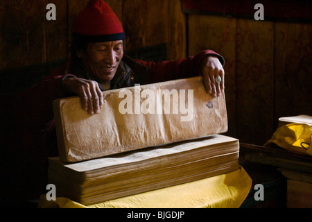 Moine bouddhiste tibétain avec des textes sacrés dans le village de SAMDO autour sur le MANASLU TREK - NUPRI RÉGION, NÉPAL Banque D'Images