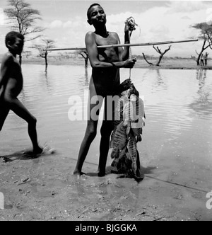 L'Éthiopie, 1950. Une photographie par J Allan Paiement d'un garçon, fiers de présenter sa grande prise de poissons, le lac Abiata, vallée du Rift. Banque D'Images