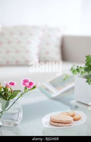 Les fleurs et les cookies sur une table de salon Banque D'Images