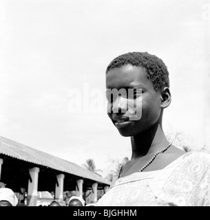 L'Afrique, 1950. Photographie par J Allan Paiement d'une jeune femme du Mozambique. Banque D'Images