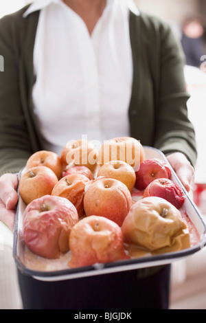 Woman holding pommes cuites sur la plaque de cuisson - Banque D'Images