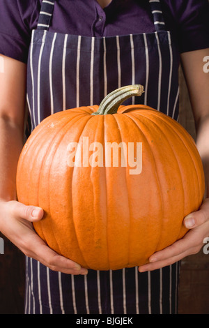 Woman holding large orange citrouille - Banque D'Images