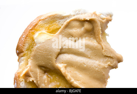 Beurre d'Arachide crémeux sur hot buttered toast isolés contre fond blanc. Banque D'Images