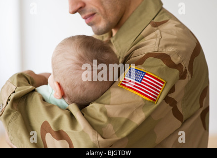 Soldier holding baby Banque D'Images