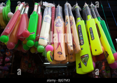 L'Inde, le Kerala, Calicut, Kozhikode, SM Street, en plastique coloré cricket bats étendus dehors toy shop Banque D'Images