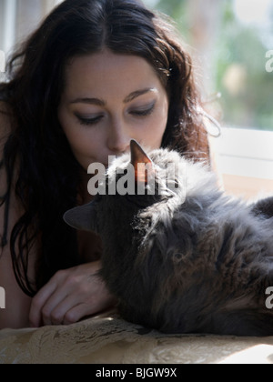 Femme sur un banc de la fenêtre avec son chat Banque D'Images