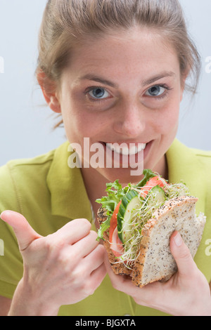 Femme souriante avec sandwich - Banque D'Images