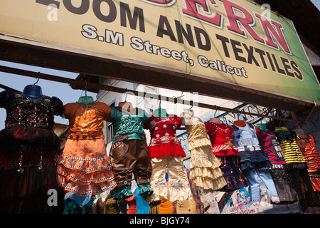 L'Inde, le Kerala, Calicut, Kozhikode, SM, rue colorée criardes les vêtements pour enfants boutique vêtements étendus dehors Banque D'Images