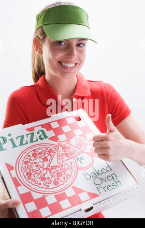 Femme souriante avec boîte à pizza, giving Thumbs up sign - Banque D'Images