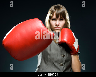 Businesswoman wearing boxing gloves Banque D'Images