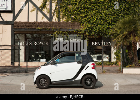 Photo humoristique d'une Smart garé à l'extérieur de la salle d'exposition d'un concessionnaire Bentley et Rolls Royce dans Beverly Hills, CA Banque D'Images