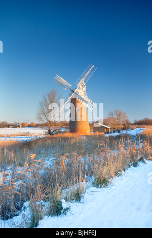 Le Leaning Hardley Moulin de drainage à la première lumière à la suite de neige en hiver sur les Norfolk Broads Banque D'Images