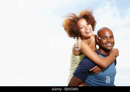 Man giving woman a piggy back ride Banque D'Images