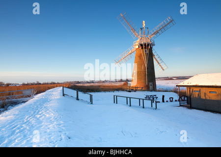 Le Leaning Hardley Moulin de drainage à la première lumière à la suite de neige en hiver sur les Norfolk Broads Banque D'Images
