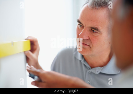 Les hommes mur de mesure Banque D'Images