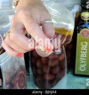 Les doigts de womans holding une olive de la société Olyfberg décroche à Swellendam Country Market sur la Garden Route en Afrique du Sud Banque D'Images