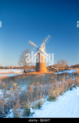 Le Leaning Hardley Moulin de drainage à la première lumière à la suite de neige en hiver sur les Norfolk Broads Banque D'Images