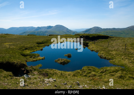 Sur la crête de Carrigbyrne Hill, près de Leenane, comté de Galway, Irlande. Les Maumturk Mountains dans la distance. Banque D'Images