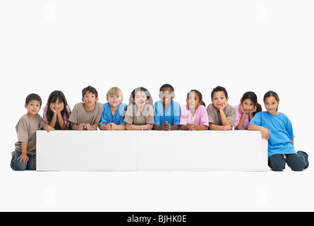 Des enfants assis dans une rangée Banque D'Images