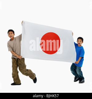 Des enfants portant un drapeau Banque D'Images