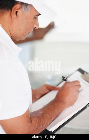 Personne réparation writing on clipboard Banque D'Images