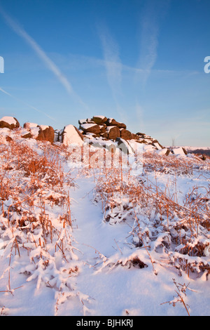 Owler Tor rocks illuminée par la lueur rose du coucher de soleil dans le parc national de Peak District Banque D'Images