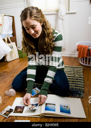 Femme assise sur le sol dans sa chambre scrapbooking Banque D'Images