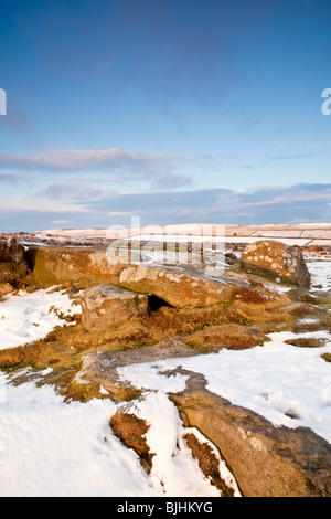 Curbar Edge illuminée par les derniers rayons du soleil couchant dans le Peak District à la suite de neige en hiver Banque D'Images