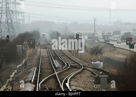 Ligne de chemin de fer fonctionne à côté de l'A249 à double chaussée route principale près de l'île de Sheppey dans le Kent Banque D'Images