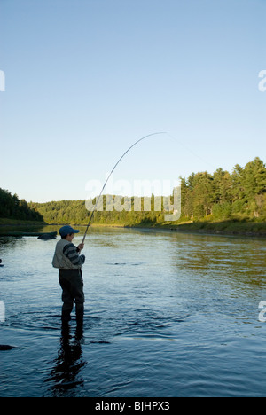 Zachary Colford, 12, joue un saumon Atlantique pêché à la mouche sur un spey rod sur la rivière Miramichi. Banque D'Images