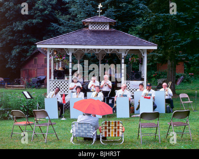 États-unis, WA, Wilkeson. Groupe jouant dans le parc ; l'un spectateur avec parapluie. Banque D'Images