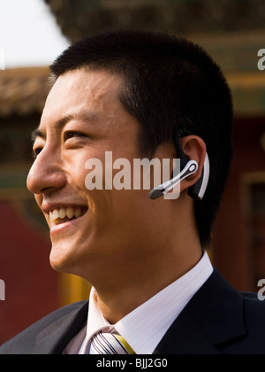 Businessman with headset smiling outdoors Banque D'Images