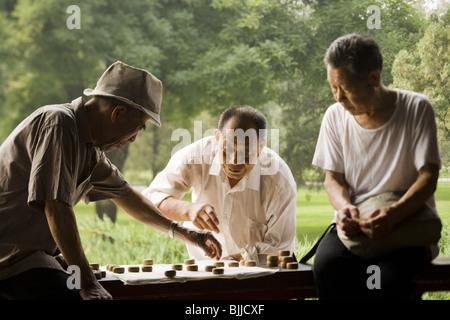 Trois hommes jouant jeu outdoors smiling Banque D'Images