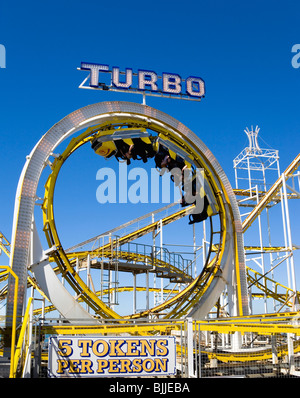 L'Angleterre, l'East Sussex, Brighton, Turbo rollercoaster amusement ride sur la jetée de Brighton avec les voitures plein de gens à l'envers Banque D'Images