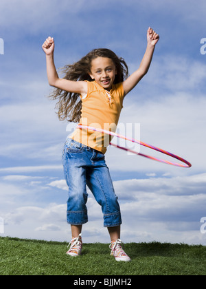 Girl Playing with hula hoop outdoors Banque D'Images