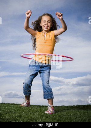 Girl Playing with hula hoop outdoors Banque D'Images