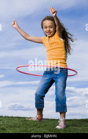 Girl Playing with hula hoop outdoors Banque D'Images