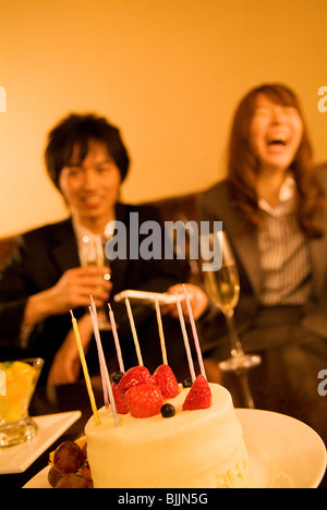 Businessman and woman celebrating avec gâteau et champagne Banque D'Images