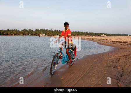 Garçon fier de faire du vélo le long de la rivière Poovar, des étangs, en face de l'hôtel Isola di Cocco Resort, Puvar, Kerala, dans le Sud Banque D'Images