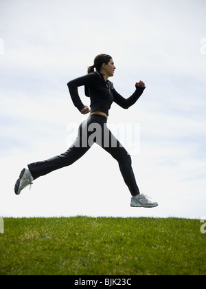 Profil de woman jogging on grass Banque D'Images