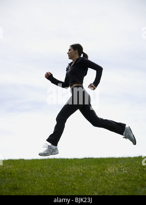 Profil de woman jogging on grass Banque D'Images