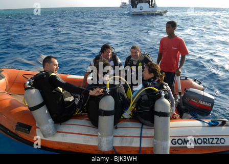 Heureux plongeurs sur un bateau gonflable prêt à plonger Banque D'Images