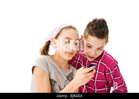 Garçon et fille à l'écoute de la musique ensemble avec des écouteurs Banque D'Images
