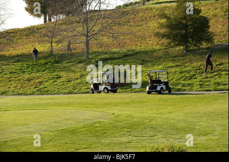 Trois golfeurs à leurs balles perdues sur le livre vert Banque D'Images