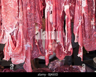 Des bandes de couleur délicatement la viande suspendue dans une boucherie dans la rue en dehors du marché de Benito Juarez Oaxaca Mexique Banque D'Images