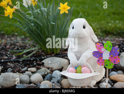 Mignon lapin de pâques blanc avec un panier d'œufs dans le jardin Banque D'Images