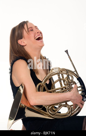 Une femme riant La joueuse de cor. Banque D'Images