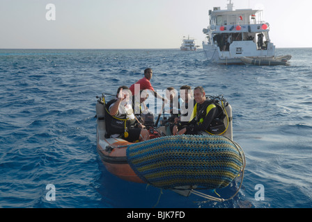 Heureux plongeurs sur un bateau gonflable prêt à plonger Banque D'Images