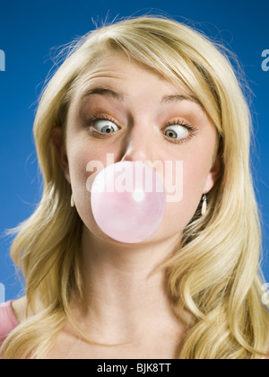 Girl blowing bubble et cross eyed Banque D'Images